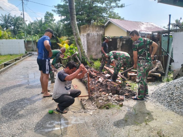 Personel Satgas TMMD ke 120 dan Warga Gali Parit Pembuatan Drainase Jalan Hiu Gang Saiyo 